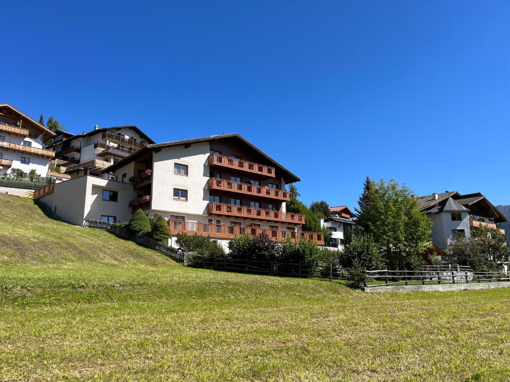 a group of buildings on a hill with a field at Apartments am Matinesweg in Serfaus