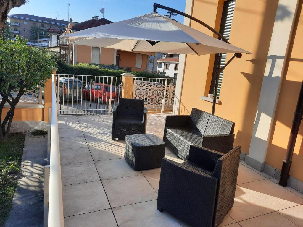 un patio con 2 sillas y una sombrilla en La Villetta a Cuneo, en Cuneo