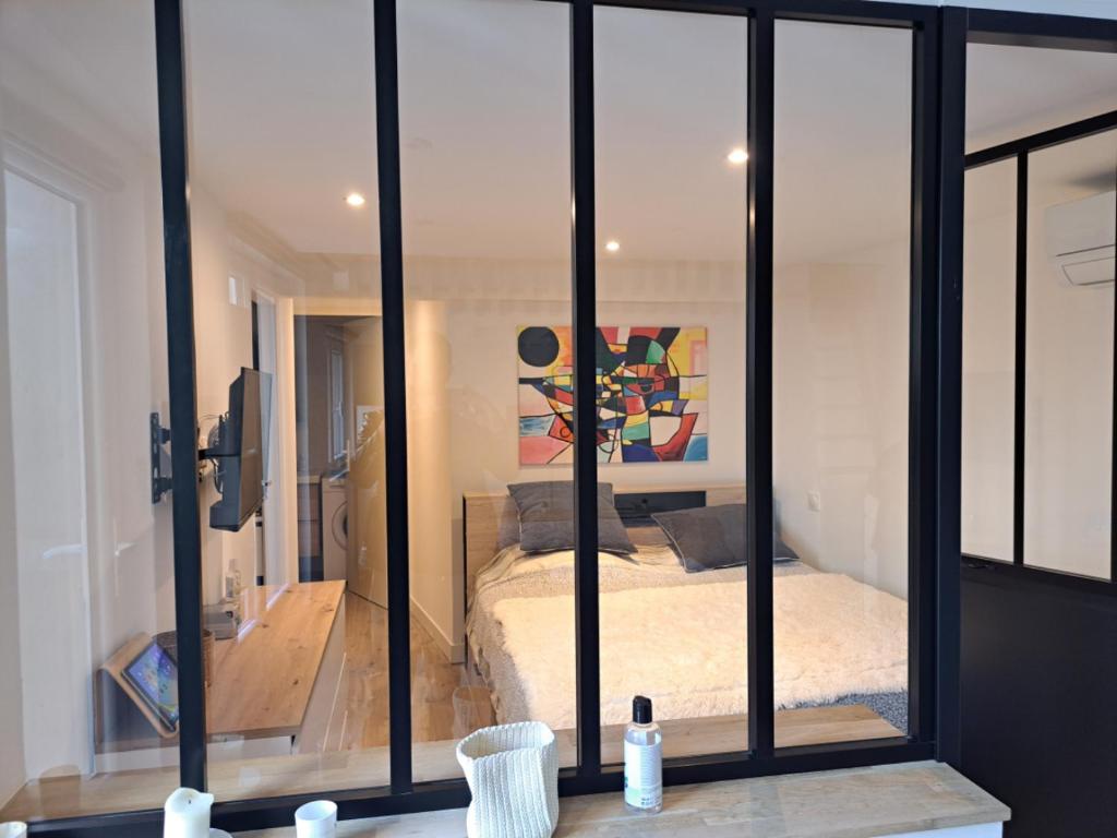 una camera con pareti in vetro e una camera con un letto di Appartement 3 pièces à 5 minutes de la plage a Saint-Laurent-du-Var