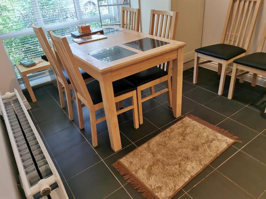 een houten tafel en stoelen in een kamer bij 3 Bedroom Home Near Windsor Castle, Legoland, & Heathrow in Slough