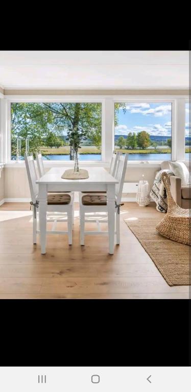 a white table and chairs in a room with a window at Hytte ved elv in Hektner