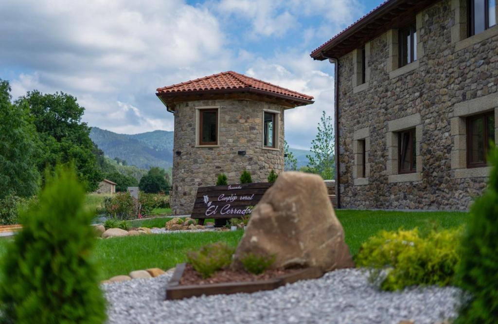 ein Steingebäude mit einem Schild vor einem Hof in der Unterkunft Complejo Rural El Cerradón in Alceda