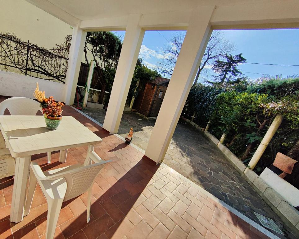 - une terrasse couverte avec une table et des chaises dans l'établissement Il Sole dell' Altopiano, à Villa Opicina