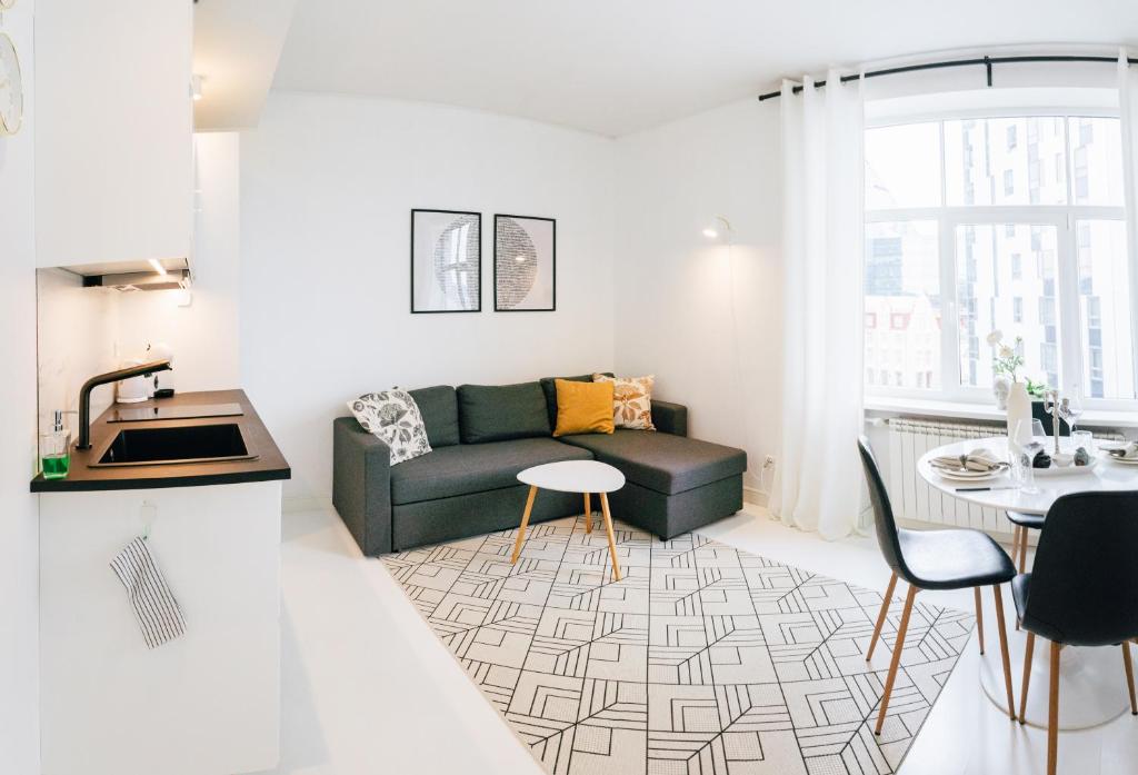 a living room with a couch and a table at City Center Maakri Apartment in Tallinn