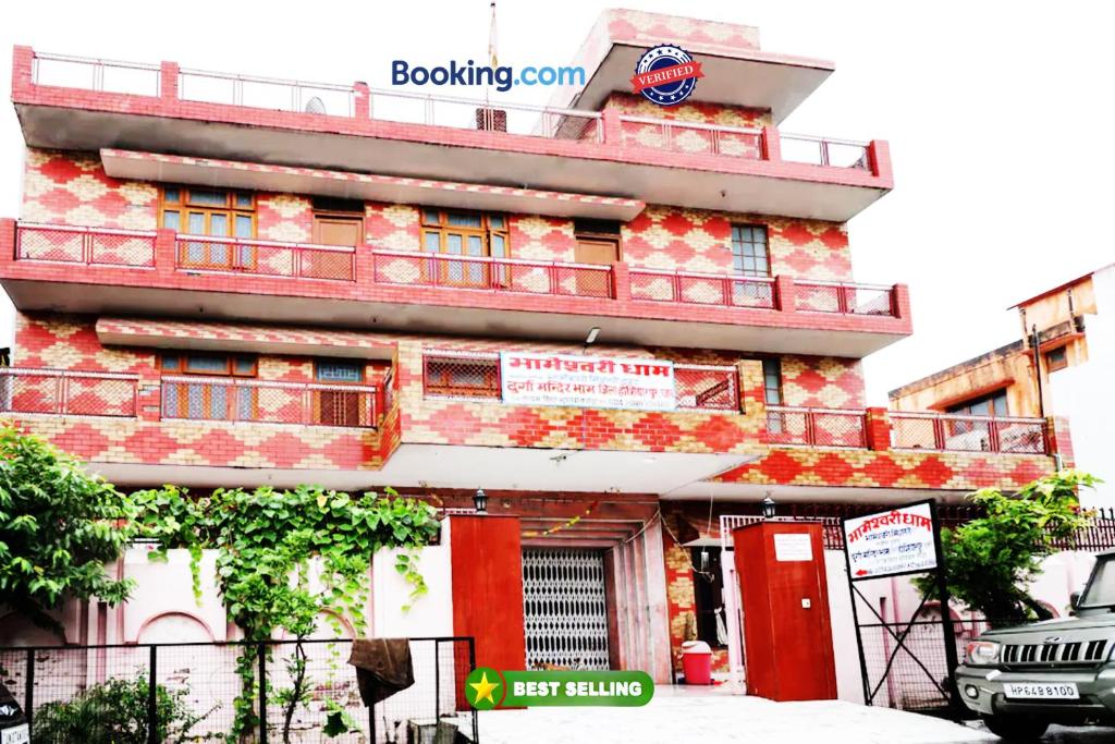 un edificio rosso con balcone sul lato di Goroomgo Bhameshwari Haridwar Near Vaishno Devi Temple a Haridwār