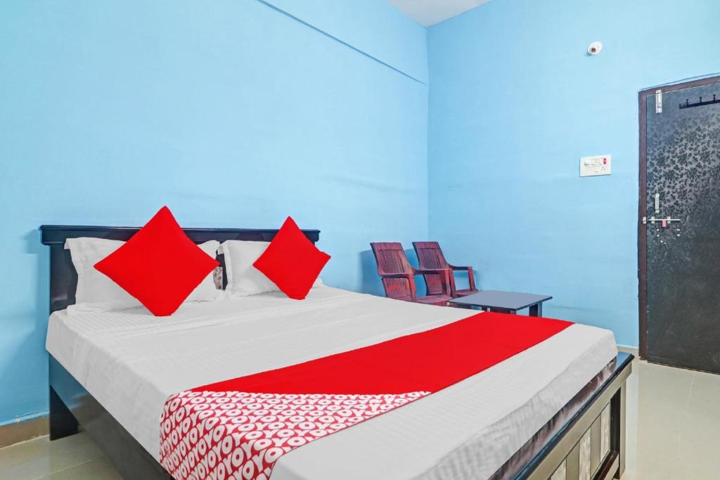 - une chambre avec un lit et des oreillers rouges dans l'établissement OYO Flagship Hanuma Residencies, à Hyderabad