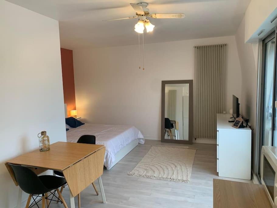 une chambre avec un lit, une table et un bureau dans l'établissement Studio 27m² - centre-ville - parking privé - Tt équipée - 1km Gare TGV, au Pouliguen