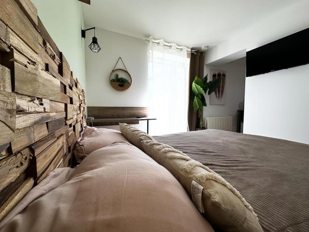 een slaapkamer met een bed en een houten muur bij Luna Monkey in Bourgoin