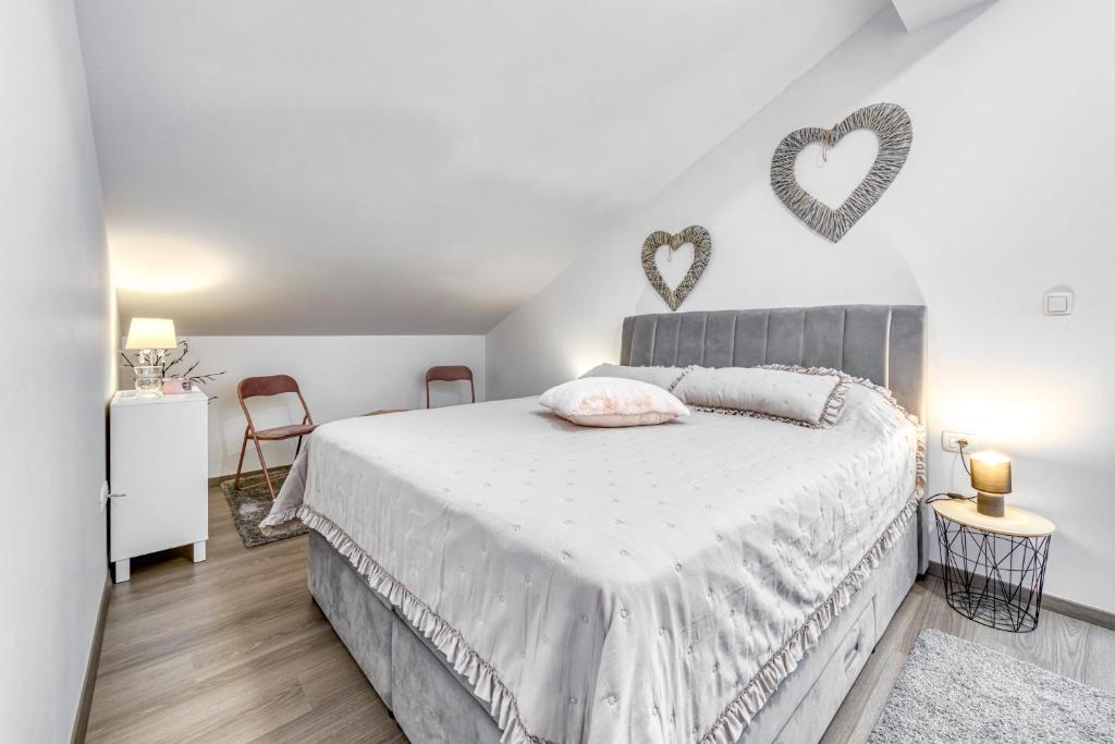 a bedroom with a bed with two hearts on the wall at Sunset view New apartment in Cavtat