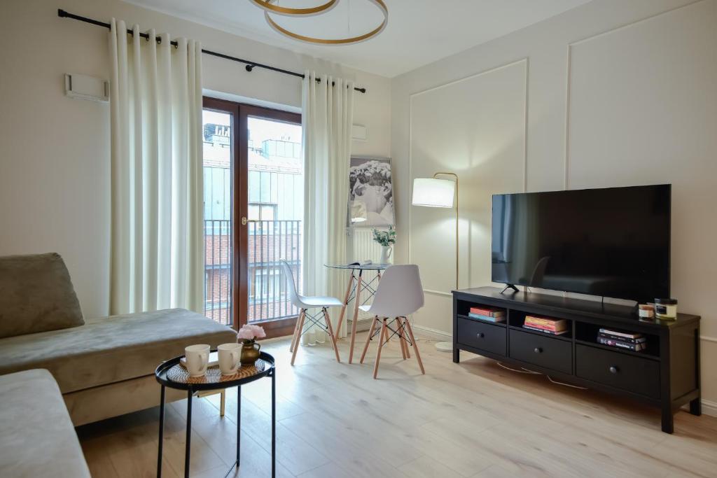 a living room with a large flat screen tv at Better Place Modern Port Praski in Warsaw