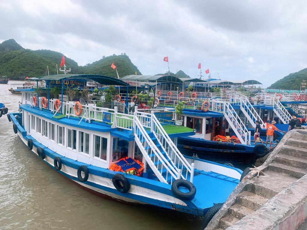 Tres barcos están atracados en un muelle en el agua. en GOLDEN LAND HOTEL, en Cat Ba