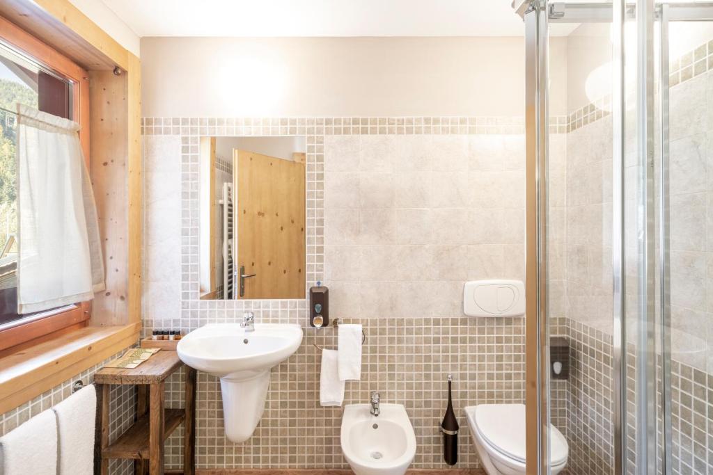 łazienka z umywalką, toaletą i prysznicem w obiekcie La Tana dell'orso Hotel & SPA w mieście Ponte di Legno