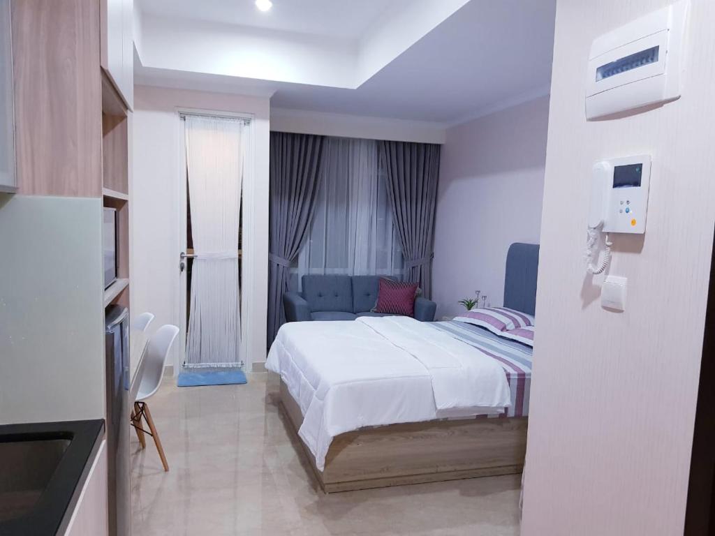 a bedroom with a white bed and a blue couch at Menteng Park in Jakarta