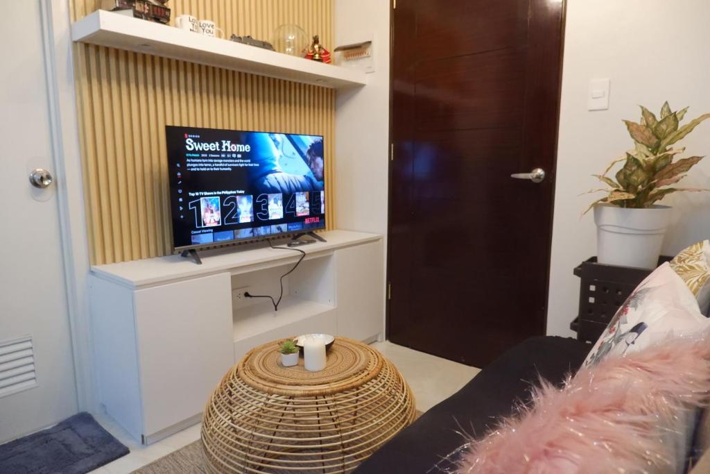 ein Wohnzimmer mit einem TV an der Wand in der Unterkunft CJ Cozy BnB in Mandaue City