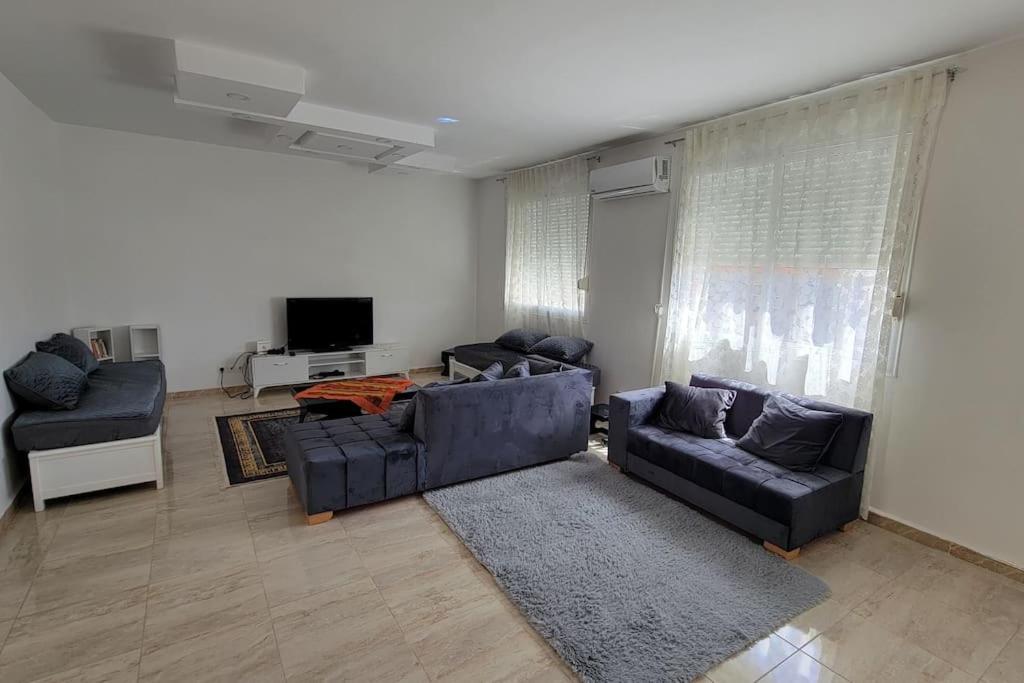a living room with two couches and a tv at Joli appartement au centre in Annaba