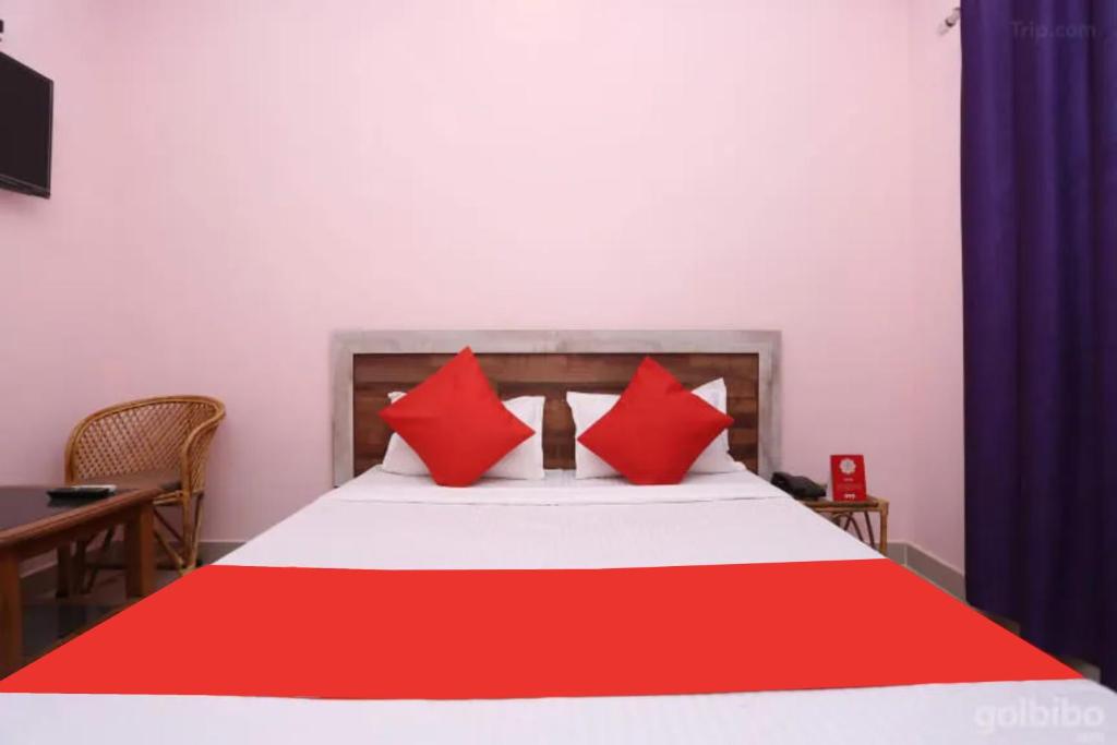 a bedroom with a bed with red pillows on it at Hotel Aradhya Gange Residency Tapovan Rishikesh - Excellent Service Awarded in Narendranagar