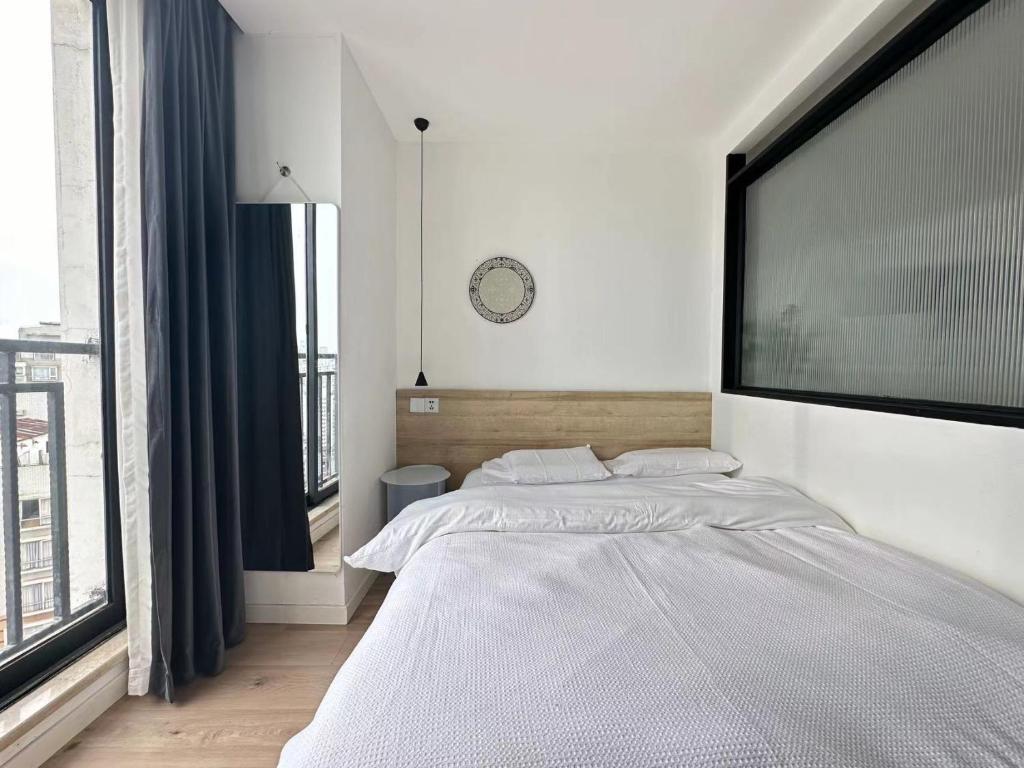 a bedroom with a large bed and a large window at 同济佳苑公寓 in Shanghai