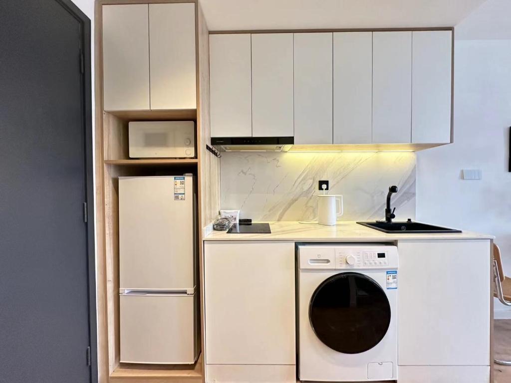 a kitchen with white cabinets and a dishwasher at 同济佳苑公寓 in Shanghai