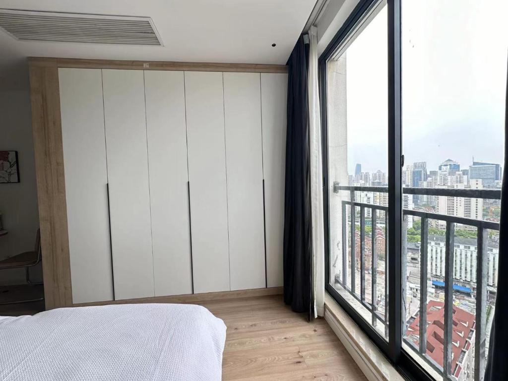 a bedroom with a bed and a large window at 同济佳苑公寓 in Shanghai