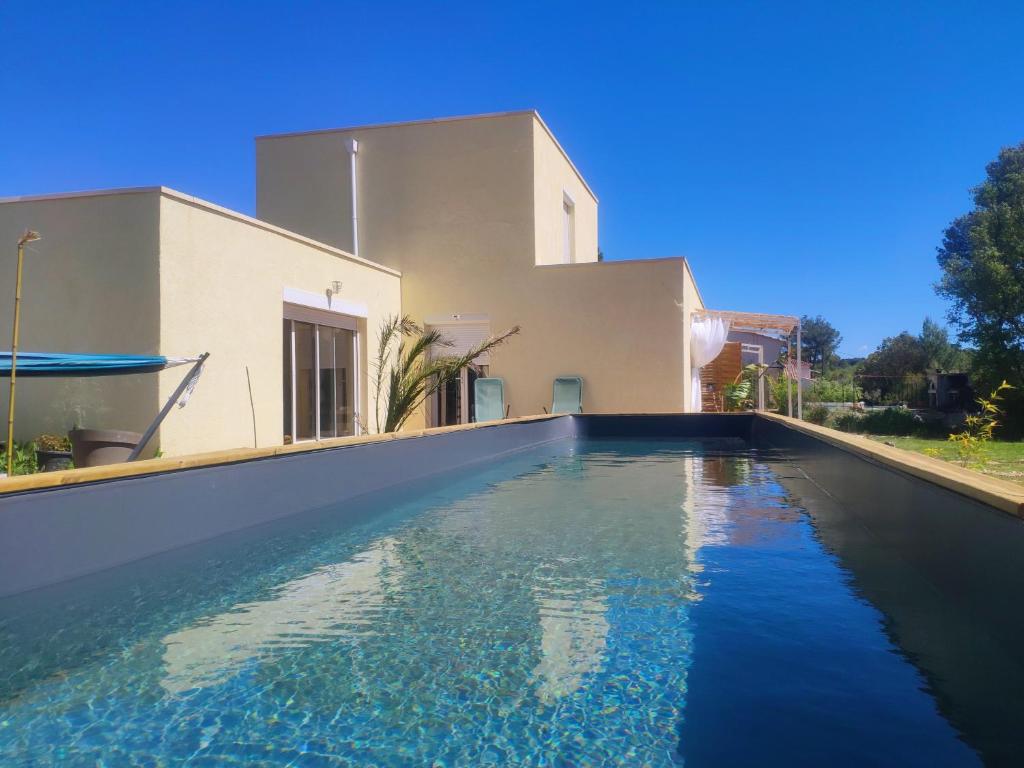 a swimming pool in front of a house at Aux amoureux de Provence in Fox-Amphoux