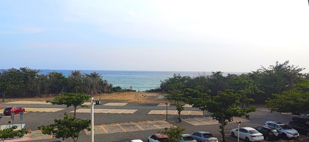 a parking lot with cars parked next to the ocean at Tz Shin Resort Hostel in Kenting