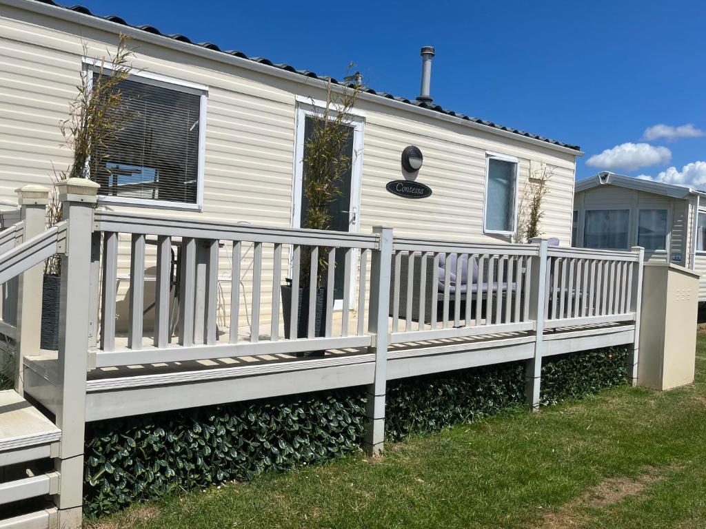 a white fence in front of a house at Pets Stay free 2 bedroom caravan at heacham beach in Hunstanton