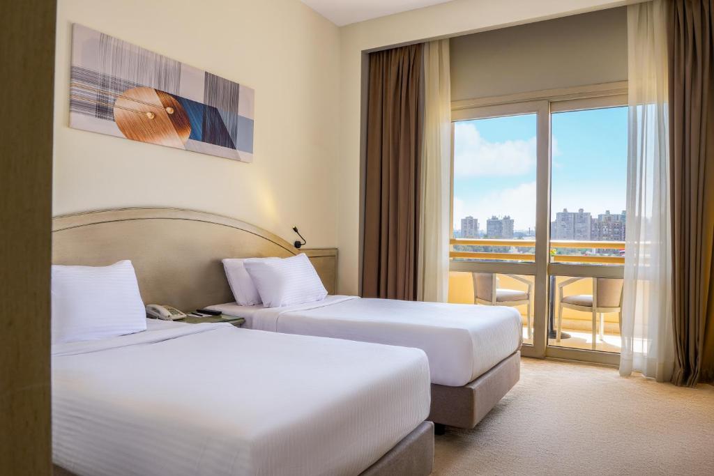 Postel nebo postele na pokoji v ubytování Triumph Plaza Hotel