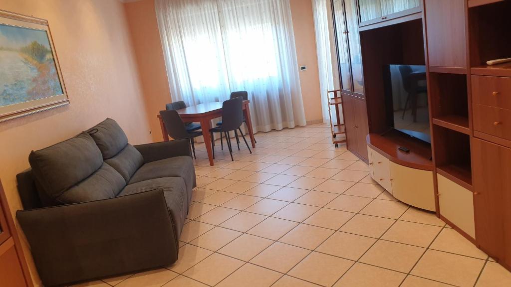 a living room with a couch and a tv and a table at Le Marille in Lido di Ostia