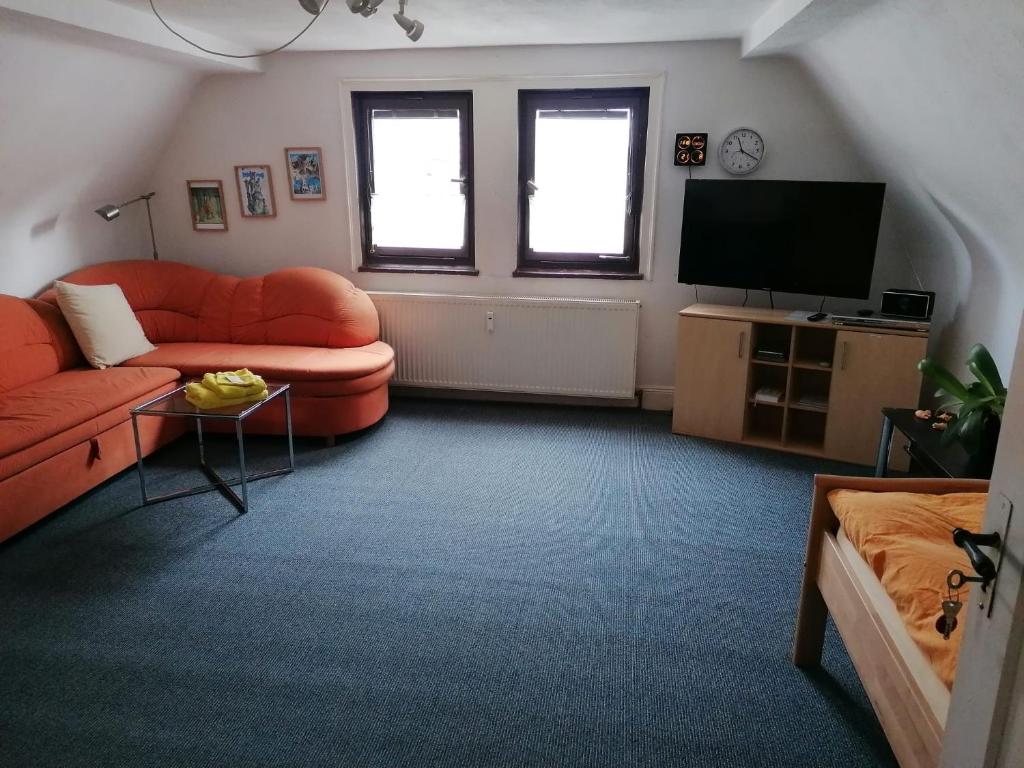 a living room with a couch and a television at Großes Gästezimmer mit Kühlschrank in Marbach am Neckar