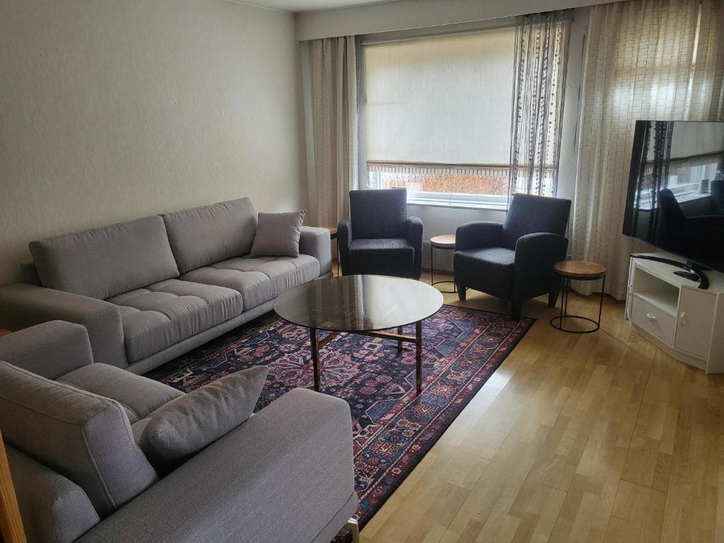 a living room with a couch and chairs and a television at Apartment 136 m2 with 3 bedrooms and 2 livingrooms, 2 floors, walking distance to all amenities in Närpiö
