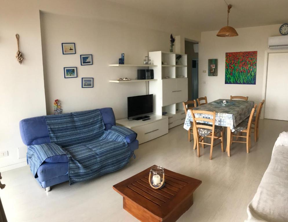 una sala de estar con un sofá y una mesa en Attico Vista Mare, en Lido di Jesolo