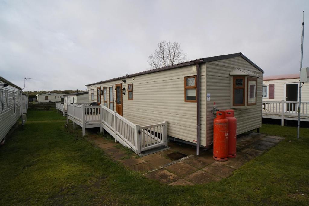 een klein wit huis met een brandkraan ernaast bij 2 bedroom two bathroom sunset lodge heachambeach in Heacham