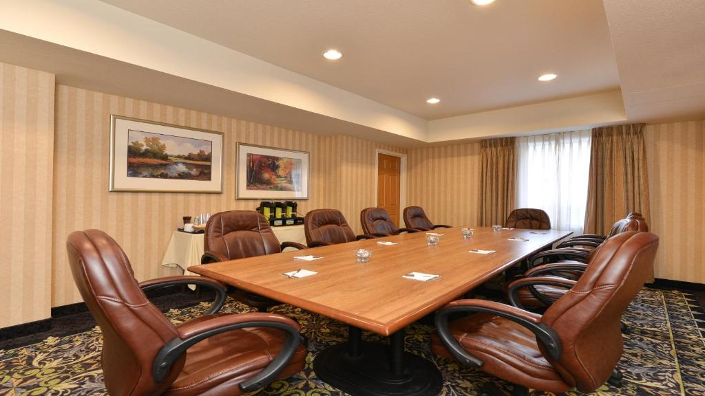 a conference room with a large wooden table and chairs at Staybridge Suites - Calgary Airport, an IHG Hotel in Calgary