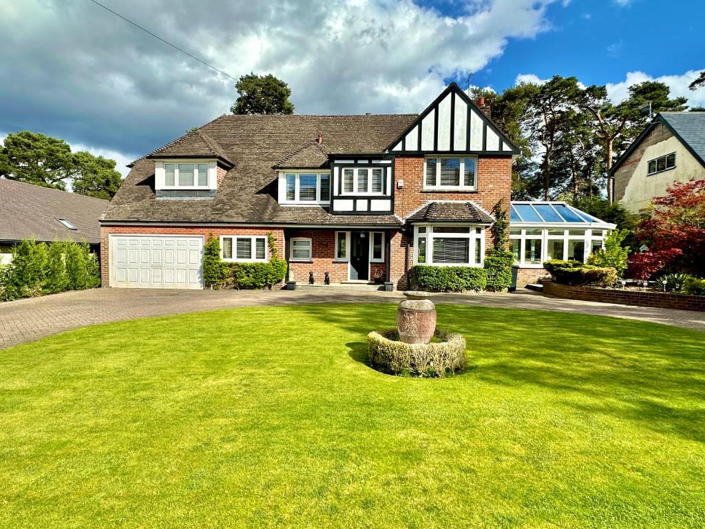a large house with a green lawn in front of it at Golf Course View - Large Four Bed Home with Garden and Parking - New Forest and Beach Links in Ferndown