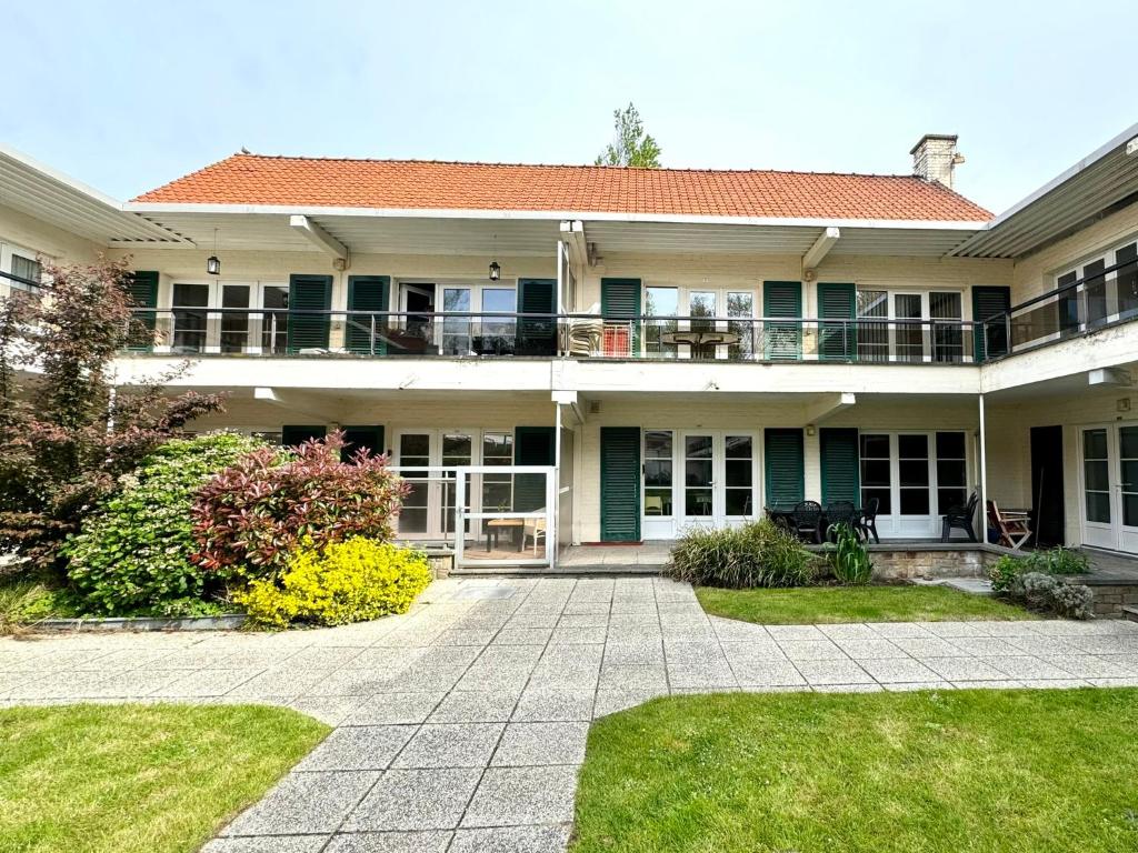 uma grande casa com um pátio e um quintal em De Haan - Dahlia 007 em De Haan