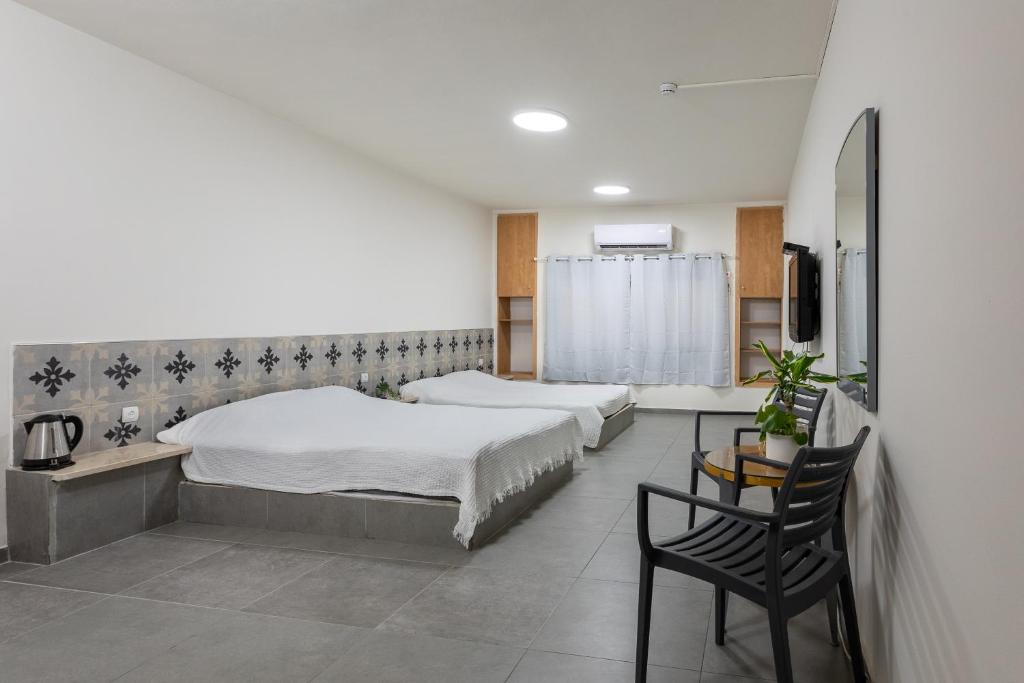 a bedroom with two beds and a table and a chair at אכסניית הנסיך הקטן-בני נוער in Eilat