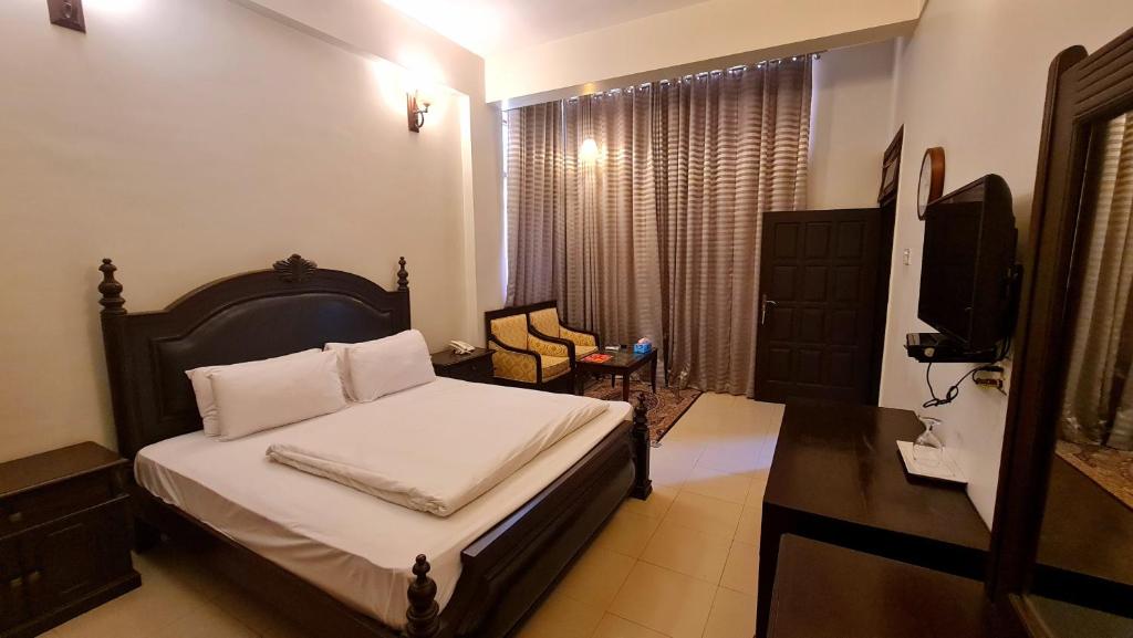 a bedroom with a bed and a television in it at Shelton Hotel & Restaurant in Sarai