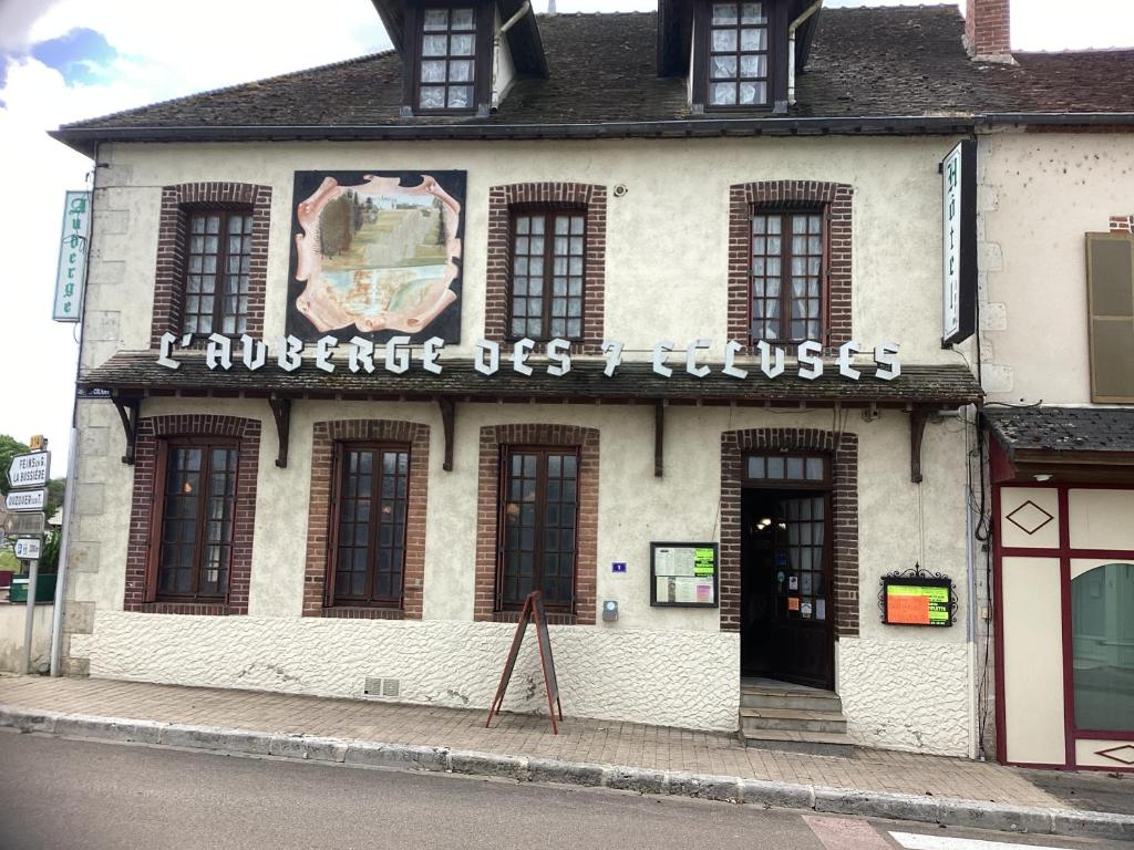 un bâtiment avec un panneau sur son côté dans l'établissement Auberge des 7 ecluses, à Rogny