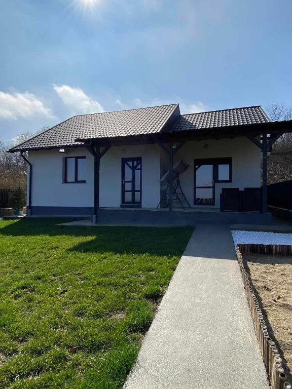 a small white house with a grass yard at Casa Bellevue in Bacău