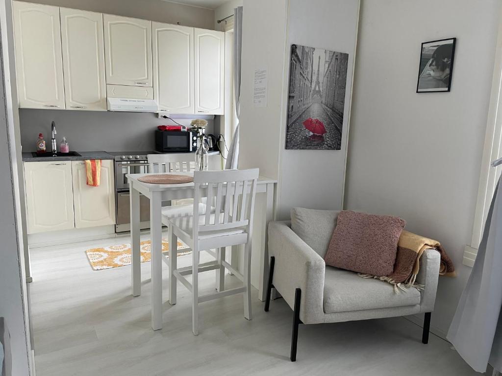 a kitchen with a white table and a chair and a table and a chair at Yksiö+autopaikka/Small apt.+free parking in Hyvinkää