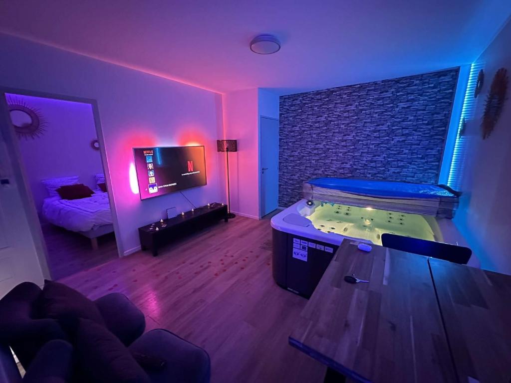 a room with a bed and a room with a tv at PrivateSpa Love Room Jacuzzi Privatif in Toulouse