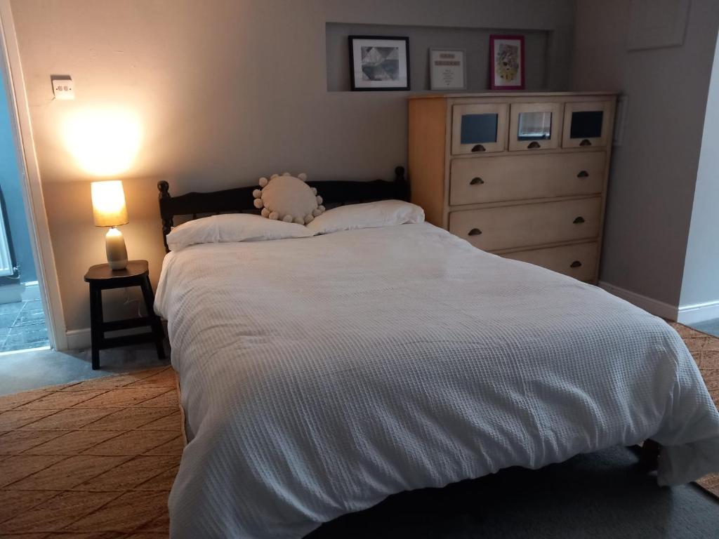 a bedroom with a large white bed and a dresser at Jasmine Haus in Moortown