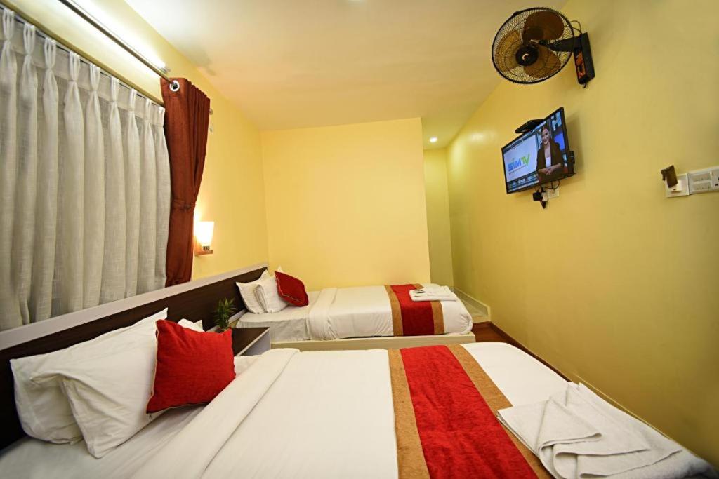 Habitación de hotel con 2 camas y TV de pantalla plana. en Hotel Aerolink, en Katmandú