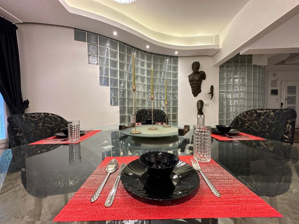 een eetkamer met een glazen tafel met rode servetten bij Modern 1-Bedroom apartment in Zamalek in Caïro