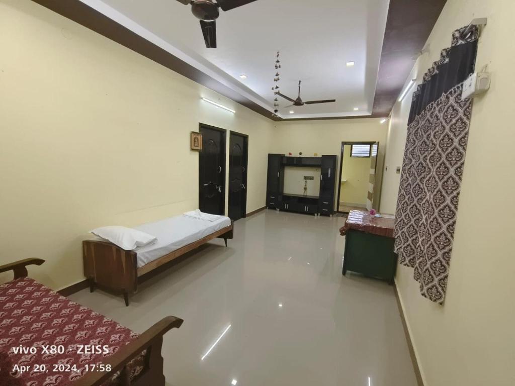a hospital room with a bed and a room with a tv at Sai Home Stay in Tiruvannāmalai