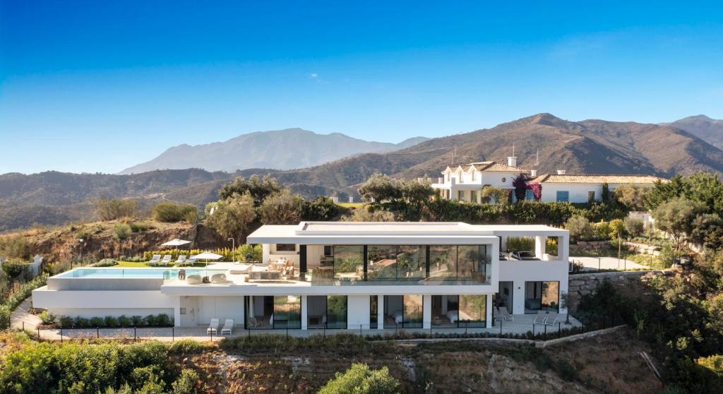 een afbeelding van een huis met bergen op de achtergrond bij Exclusive VILLA IMAGINE MARBELLA breathtaking panoramic sea views heated infinity pool in Benahavís