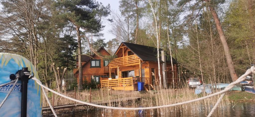 a log cabin in the middle of the water at Nowy dom całoroczny nad jeziorem wielkie parteczyny in Kurzętnik