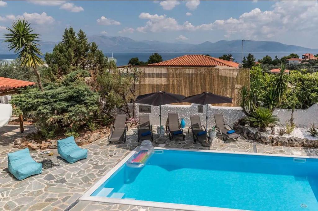 basen z leżakami i parasolami na dziedzińcu w obiekcie Casa di Soho w mieście Kalamos