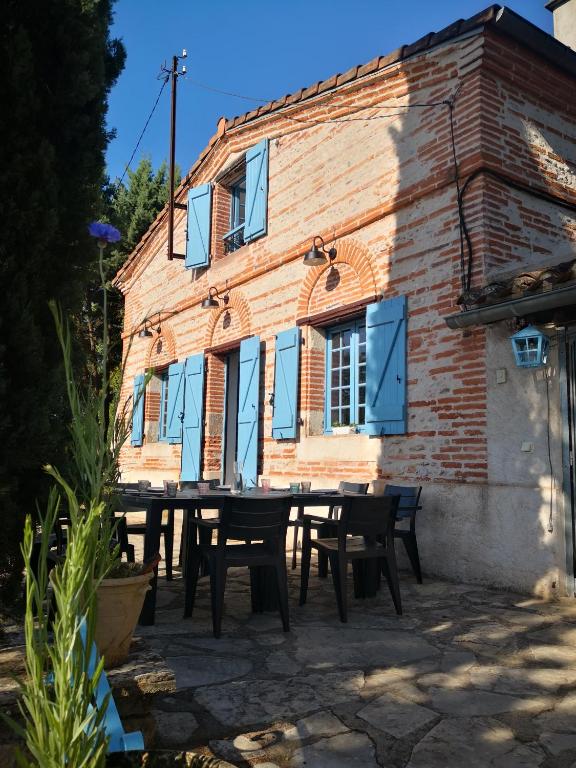 une table et des chaises devant un bâtiment dans l'établissement La planque de l'éclusier, à Castelnau-de-Lévis