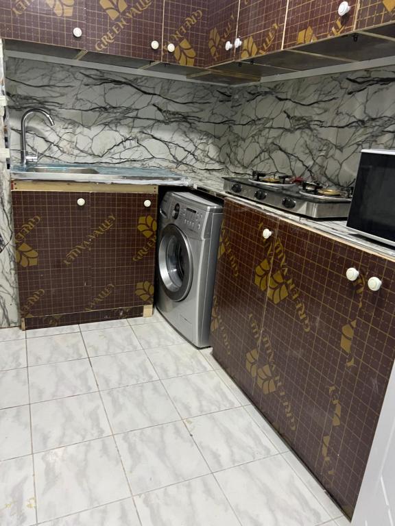 a kitchen with a washing machine and a stove at Saif Abdur Rehman Salah Al din in Dubai
